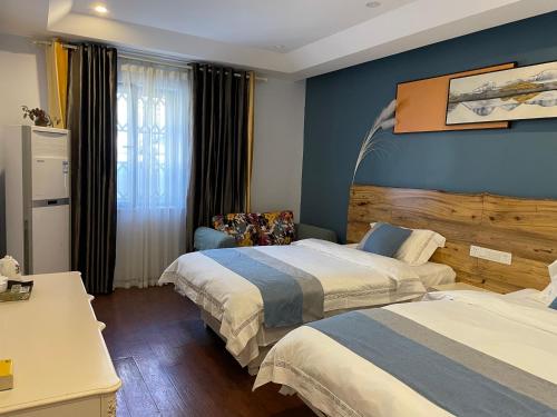 um quarto de hotel com duas camas e uma cadeira em Wesley Rosegarden 庐山卫斯里玫瑰园别墅 em Jiujiang