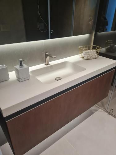 La salle de bains est pourvue d'un lavabo blanc et d'un miroir. dans l'établissement Luxury apartment Lisbon, à Lisbonne