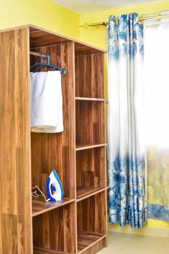 a wooden book shelf in a room with a curtain at Four seventy in Meru