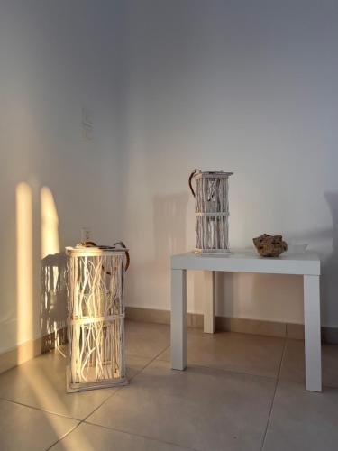 a white table with two vases sitting next to a table at Sea breeze houses in Monolithos