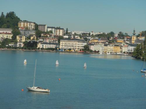 a boat in a large body of water with a city at Echo am See in Gmunden