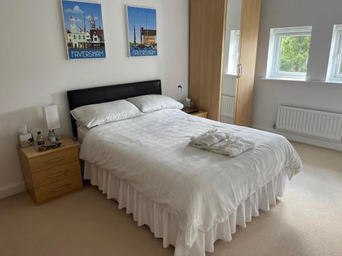 a bedroom with a large bed and a dresser and two windows at Hampton Vale, Peterborough Lakeside Large Double bedroom with own bathroom in Peterborough