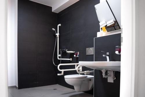 a black bathroom with a toilet and a sink at Gwuni Mopera in Leipzig
