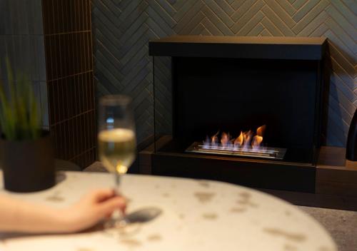 a person holding a glass of wine next to a fireplace at Fufu Kyu-Karuizawa Seiyou No Mori in Karuizawa