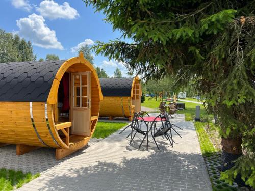 a wooden house with a table and chairs in a park at Camping u Kukačků in Horní Planá