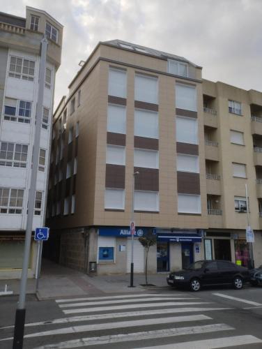 a building with a car parked in front of it at Apartamentos Mar y Playa in Moaña