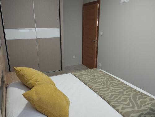 a bedroom with a bed with a yellow pillow on it at Apartamentos Mar y Playa in Moaña