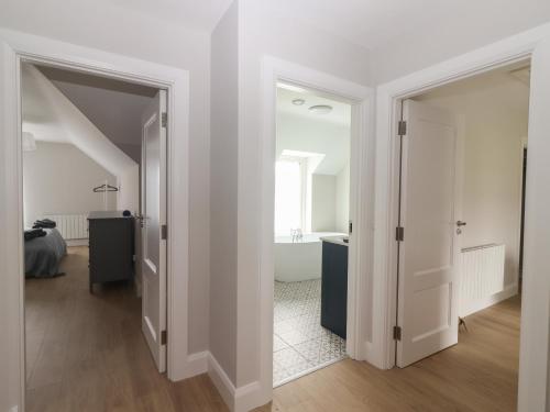 a white bathroom with a tub and a sink at 19A Lighthouse Village in Fenit