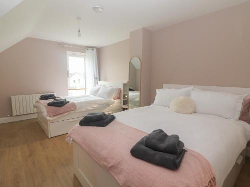 a bedroom with two beds with towels on them at 19A Lighthouse Village in Fenit