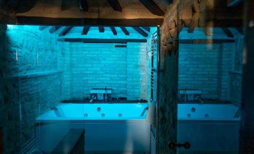 Habitación con iluminación azul y baño con bañera. en Villa Lucia - Homelike Villas, en Camporotondo di Fiastrone