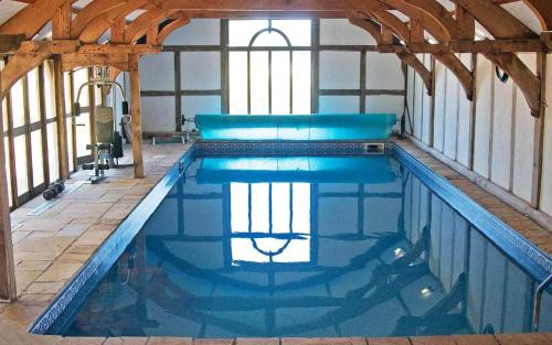 a large swimming pool in a building with at Barnacre Green Cottage with Hot Tub and Private Pool in Moreton