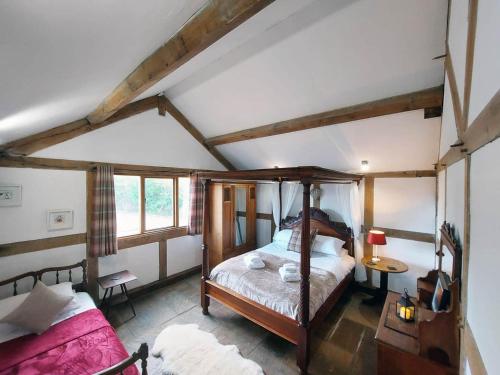 a bedroom with a four poster bed in a attic at Barnacre Green Cottage with Hot Tub and Private Pool in Moreton