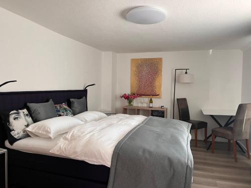 een slaapkamer met een groot bed en een tafel met een bureau bij Julia's Mosel Villa Appartement NICOLAS in Traben-Trarbach