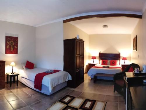 Habitación de hotel con 2 camas y escritorio en Eco Lodge en Lephalale