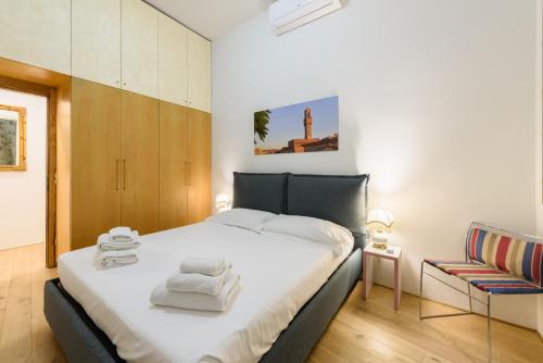 Un dormitorio con una cama grande y una silla. en Lucky House by Mmega, en Florencia