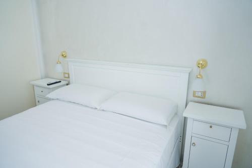 a bedroom with a white bed and two night stands at La casa in centro in Salerno