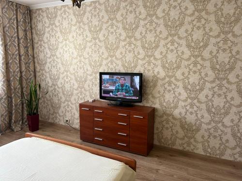 a television sitting on a dresser in a bedroom at Apartments Kharkivs'ke highway in Kyiv