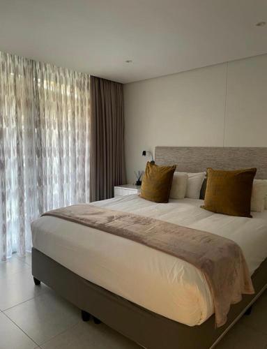 a large bed in a bedroom with a large window at Umhlanga Ocean Dunes in Umhlanga
