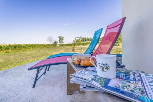 a table and chairs with a bowl of bread and a cup at Les Petits Faulongs in Sauviac