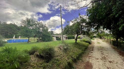 a dirt road next to a green field with trees at Casa Ana new in 2025 high speed Starlink wifi in Buzet