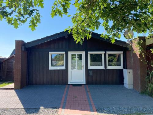a garage with a white door and two windows at Ferienpark Fedderwardersiel in Fedderwarderdeich