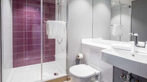 uma casa de banho com um chuveiro, um WC e um lavatório. em Premier Inn Nürnberg City Opernhaus em Nurembergue