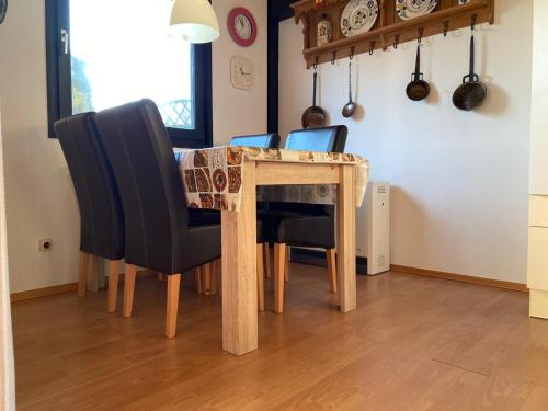 a dining room table with black chairs and a tableablish at Ferienpark Fedderwardersiel in Fedderwarderdeich