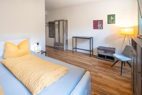 a bedroom with a bed with a yellow blanket on it at Gwuni Mopera in Leipzig