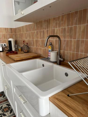 une cuisine avec un grand évier blanc dans l'établissement Casa Andréa Agreable T3 avec grand jardin à 3mn de la plage, à Sanary-sur-Mer