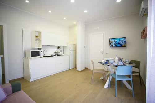 a living room with a table and a kitchen at StabiaHome City and Sea in Castellammare di Stabia