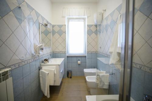 a bathroom with a sink and a toilet and a window at StabiaHome City and Sea in Castellammare di Stabia