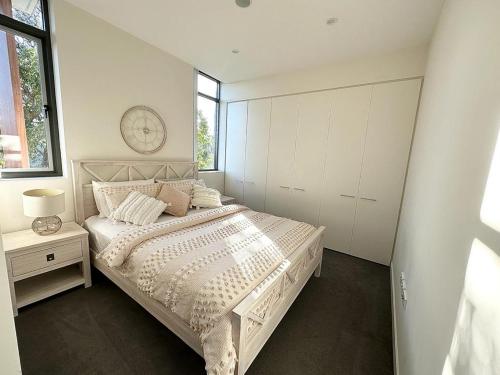 1 dormitorio con 1 cama y reloj en la pared en Private ensuite room in a beautiful nature area, en Sídney