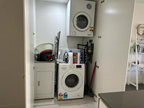 a kitchen with a washing machine and a microwave at Private ensuite room in a beautiful nature area in Sydney