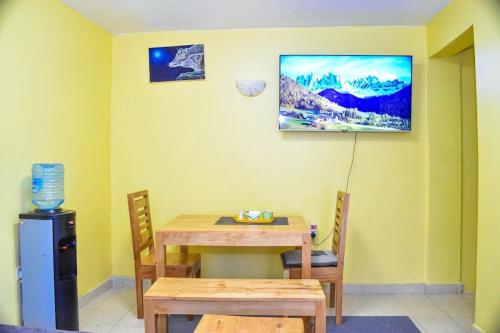 uma sala de jantar com mesa e cadeiras e uma imagem na parede em Four seventy em Meru