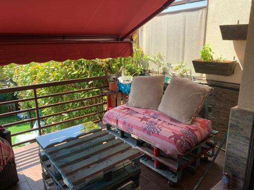 a chair on a balcony with a red awning at Mandatory Stop House with Private Pool in Llanera