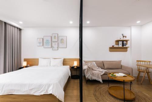 a bedroom with a bed and a couch at LAGOM APARTMENT AND HOTEL in Da Nang