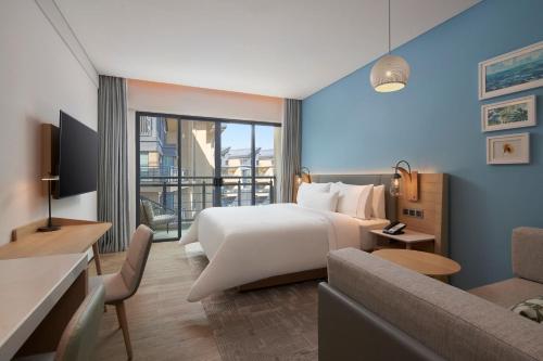 廈門市にあるElement Xiamen Tong'anの大きなベッドとソファが備わるホテルルームです。