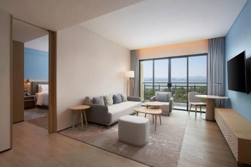 a living room with a couch and a tv at Element Xiamen Tong'an in Xiamen