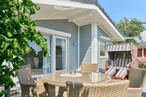 a patio with a table and chairs on a house at Mein Ankerpunkt in Simonsberg