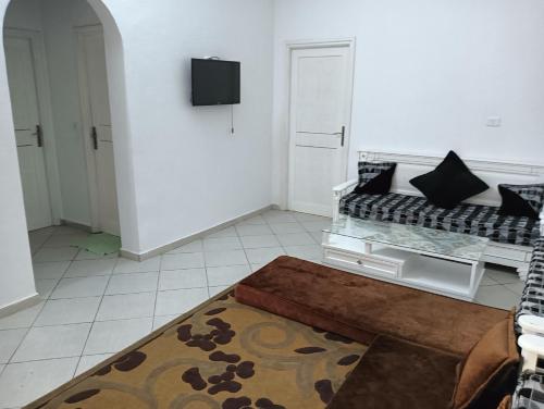 sala de estar con sofá y alfombra en Maison a louer à kelibia en Qulaybīyah