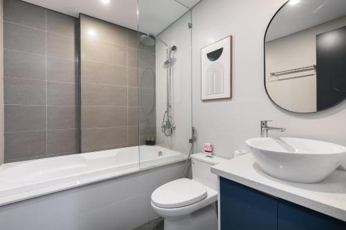 a bathroom with a sink and a toilet and a mirror at LAGOM APARTMENT AND HOTEL in Da Nang