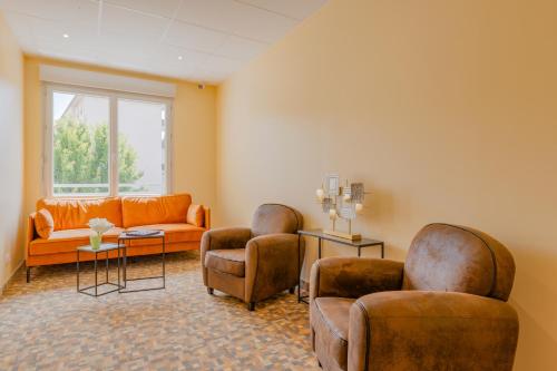 a waiting room with two chairs and a couch at Hôtel de la Tour in La Tour-du-Pin
