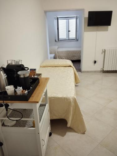 a room with two beds and a table with a stove at Ostello Villafranca in Pignola