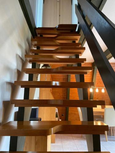 a wooden staircase in a house with a wooden railing at Ferienpark Fedderwardersiel in Fedderwarderdeich