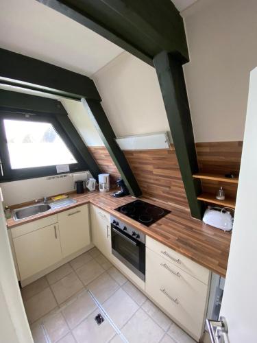 a small kitchen with white cabinets and a stove at Ferienpark Fedderwardersiel in Fedderwarderdeich