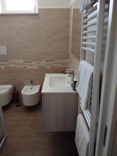 a bathroom with a sink and a tub and a toilet at Ostello Villafranca in Pignola