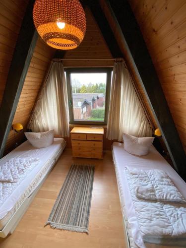two beds in a room with a window at Ferienpark Fedderwardersiel in Fedderwarderdeich