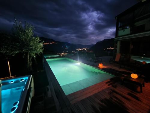 a swimming pool on the side of a building at night at Bella Flocon appartements min 2 Nights Special weekly and monthly prices in Savièse