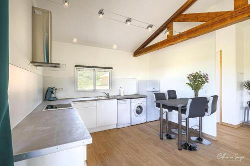 a kitchen with a table and chairs in a room at Les Petits Faulongs in Sauviac