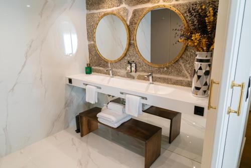 a bathroom with a sink and two mirrors at Quinta de Silvalde in Santo Tirso